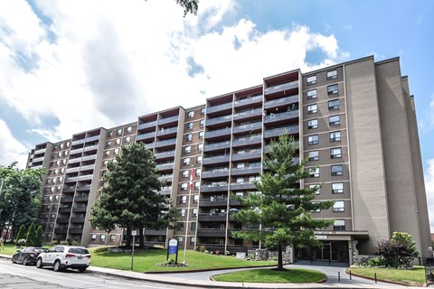 A large apartment building with a parking lot in front.