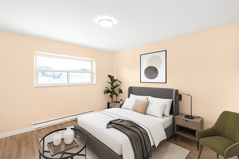 A bedroom with a bed, nightstand, and chair.