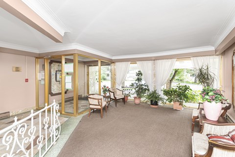 A living room with a white railing and a glass door.
