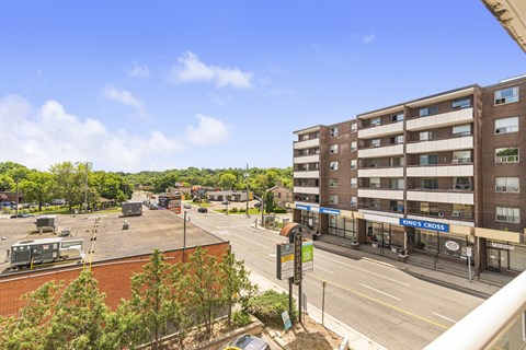 A view of a street with a building on the right and a sign that says "KINGS CROSS".