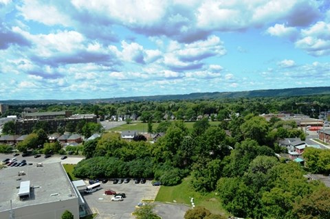A parking lot is in the foreground of a town.
