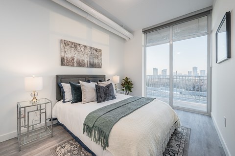 A bedroom with a large bed and a view of the city.