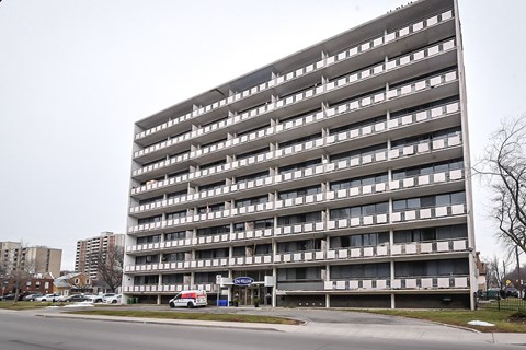 A large grey building with many windows and balconies.