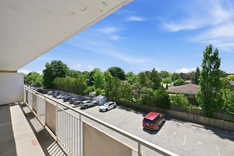 A parking lot with cars and a red car in the foreground.