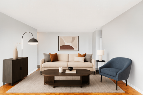 A living room with a white couch, a brown coffee table, a blue armchair, and a brown cabinet.