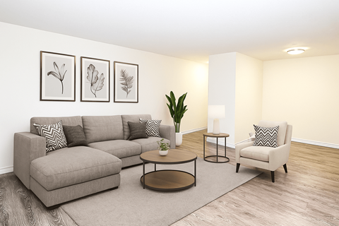 A living room with a grey sofa, a coffee table, a chair, and three framed pictures on the wall.