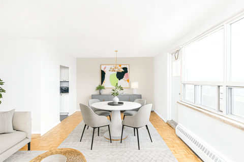 A dining room with a white table and chairs.