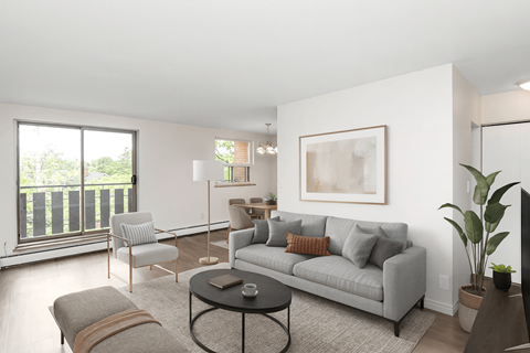 A living room with a grey couch, a coffee table, and a large window.