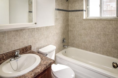 A bathroom with a sink, toilet, and bathtub.