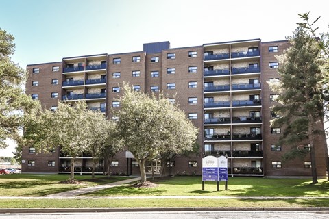 A large brick building with a blue sign in front of it.