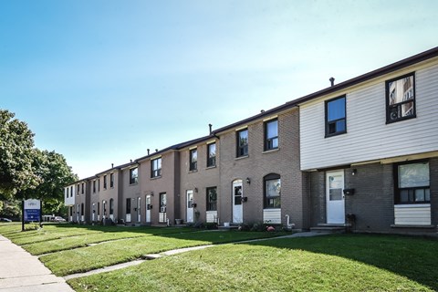 A row of houses with a blue sign in front.