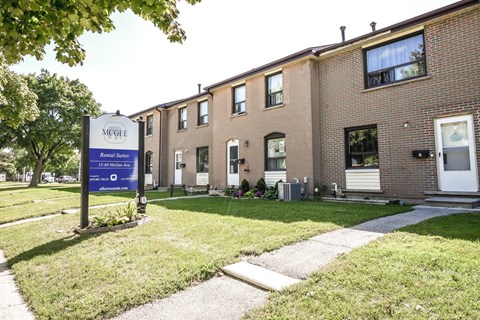 A McGehee senior living community with a blue sign in front of the building.
