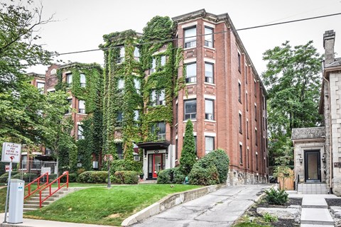 A red brick building with ivy growing on the side.