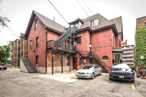 A red brick building with a black car parked in front.