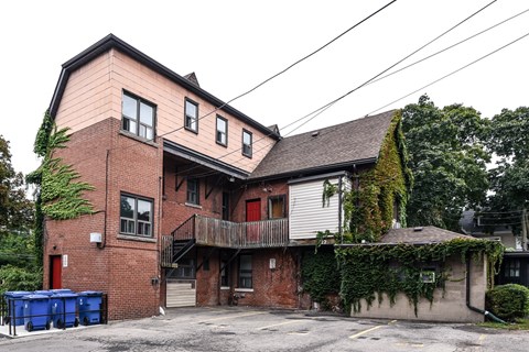 A two-story building with a red door and a balcony.