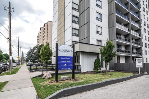 A sign for Wedgewood Apartments is displayed in front of a building.