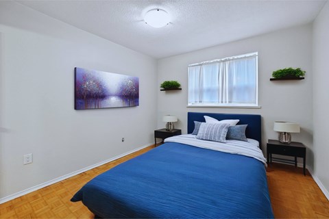 A bedroom with a blue bed and a painting on the wall.