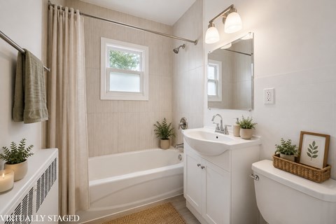 A bathroom with a white tub, sink, and toilet.