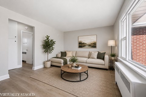 A living room with a couch, coffee table, and a painting on the wall.