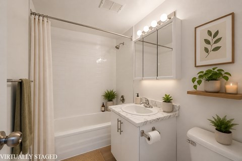 A bathroom with a white sink and a mirror above it.