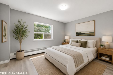 A bedroom with a large bed and a painting on the wall.