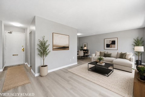 A living room with a couch, coffee table, and pictures on the wall.
