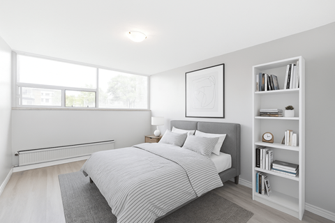 A bedroom with a large bed and a bookshelf.