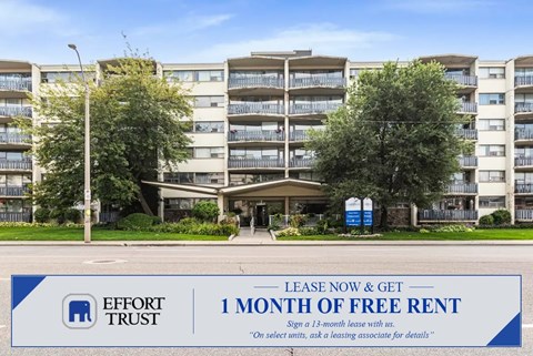 A large apartment complex with a sign offering a free month of rent.