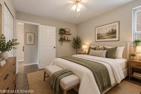 A bedroom with a bed, a bench, and a painting on the wall.