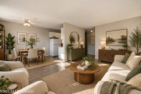 A living room with a white couch, a coffee table, and a dining table with chairs.
