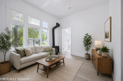 A living room with a white couch and a wooden coffee table.