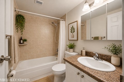 A bathroom with a white tub, toilet, and sink.
