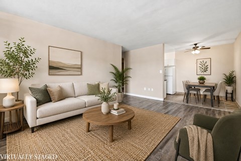 A living room with a white couch, a wooden coffee table, and a painting on the wall.
