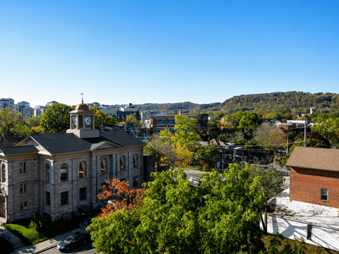 A large building with a clock tower sits in the middle of a town.