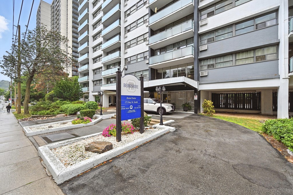 The image shows a street view of a residential area with apartment buildings and a sign that reads "BENSONITE".