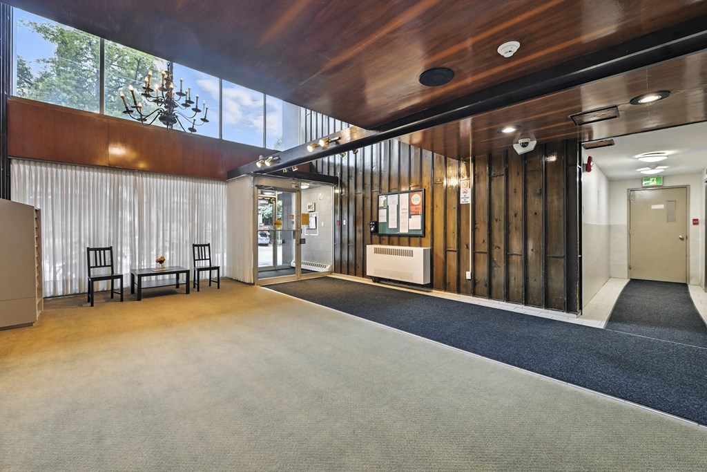 A modern office lobby with a wooden ceiling and a glass wall.