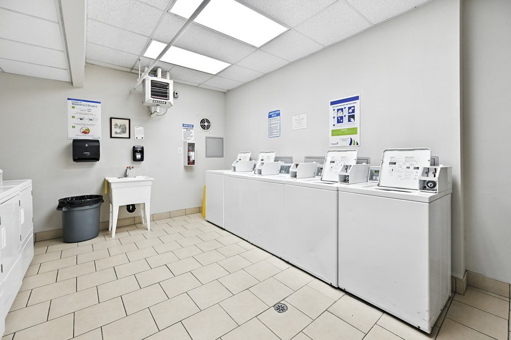 A clean, white medical office with a trash can and a small table.