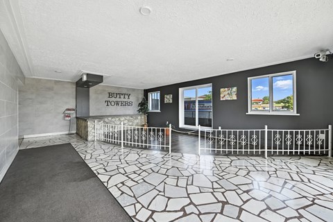 A room with a tiled floor and a sign that says "BUTTY TOWERS".