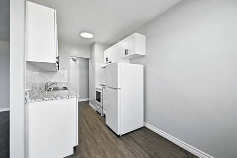 A kitchen with white appliances and cabinets.
