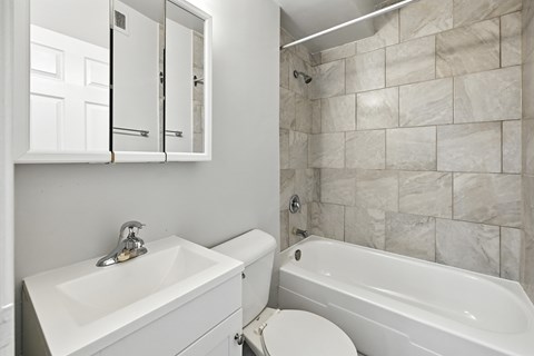A white bathroom with a sink, toilet, and bathtub.
