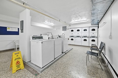 A yellow caution sign is on the floor next to a white piece of equipment.