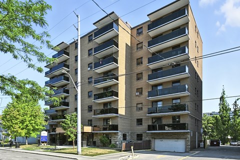 A large apartment building with balconies on the second floor and a garage door on the ground floor.