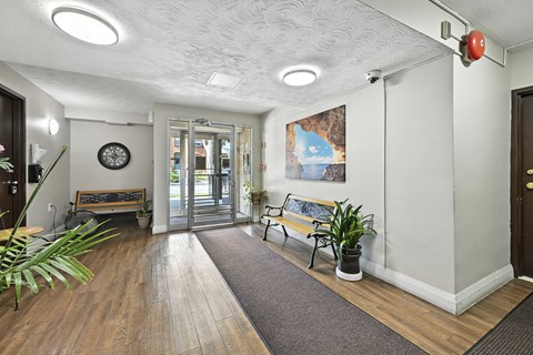 A hallway with a bench and a plant.