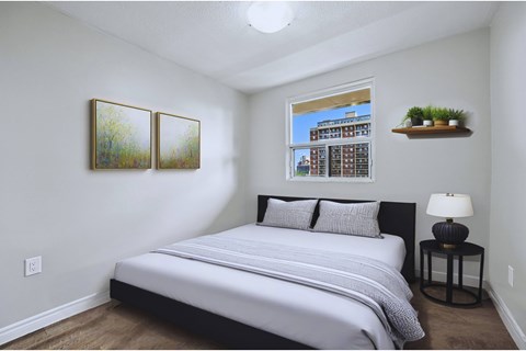 A bedroom with a large bed and two framed pictures on the wall.