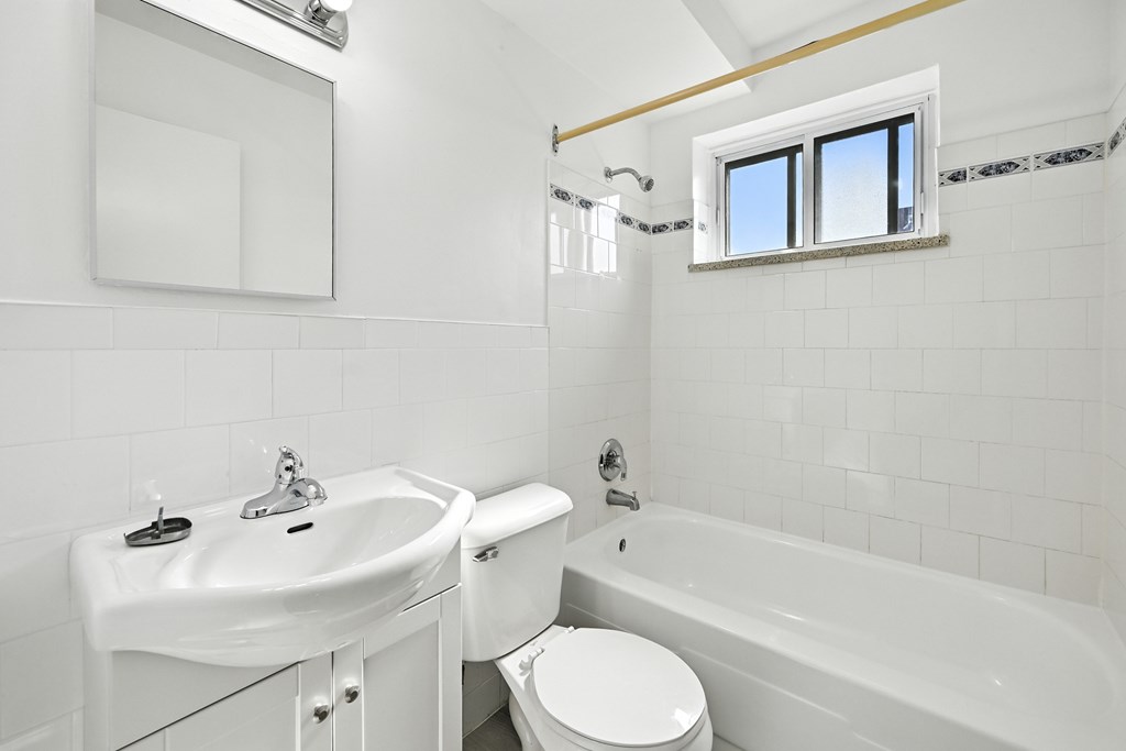 A white bathroom with a toilet, sink, and bathtub.