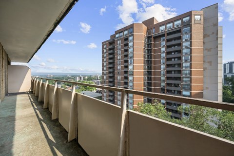 A long balcony with a building in the background.