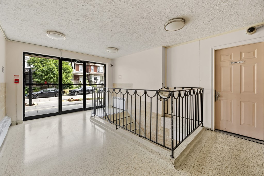 A view of a foyer with a black gate and a brown door.