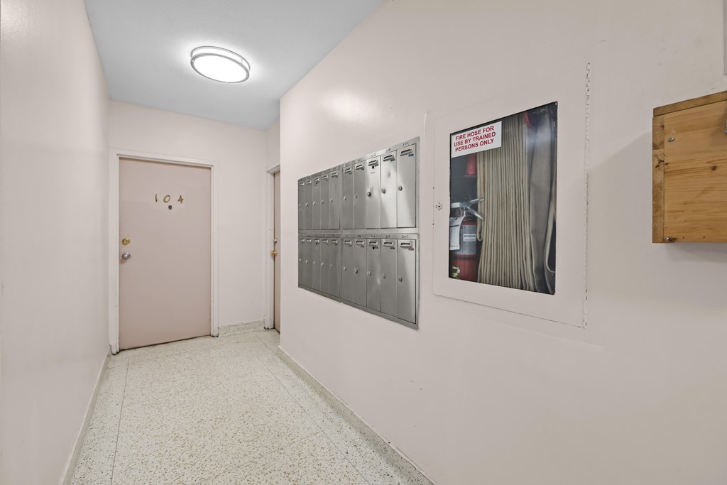 A hallway with a pink door and a poster on the wall.