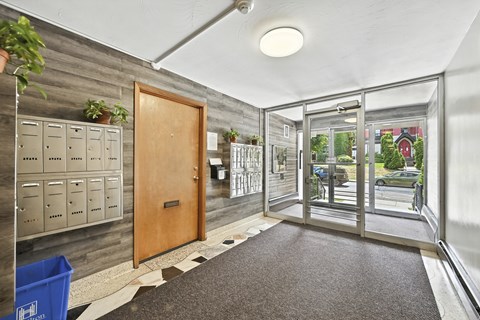 A hallway with a wooden door and a metal railing.