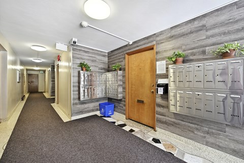 A hallway with a blue bin on the floor.